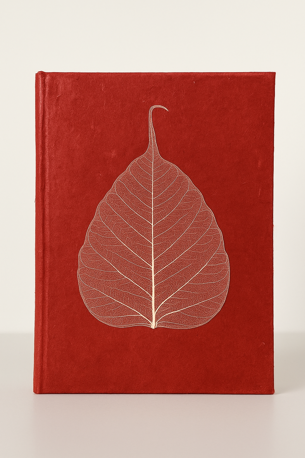 Handmade red Lokta notebook with real Bodhi leaf design, crafted from tree-free Nepali paper.