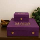 Purple boxes with 'MAHA' and 'MAHA Treasures' text on a wooden surface with a plant in the background.