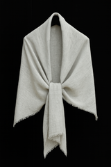 Light gray handwoven basket weave linen-silk stole draped in a soft V-shape with knotted front and fringe edges, displayed on a black background – artisan-crafted in Nepal