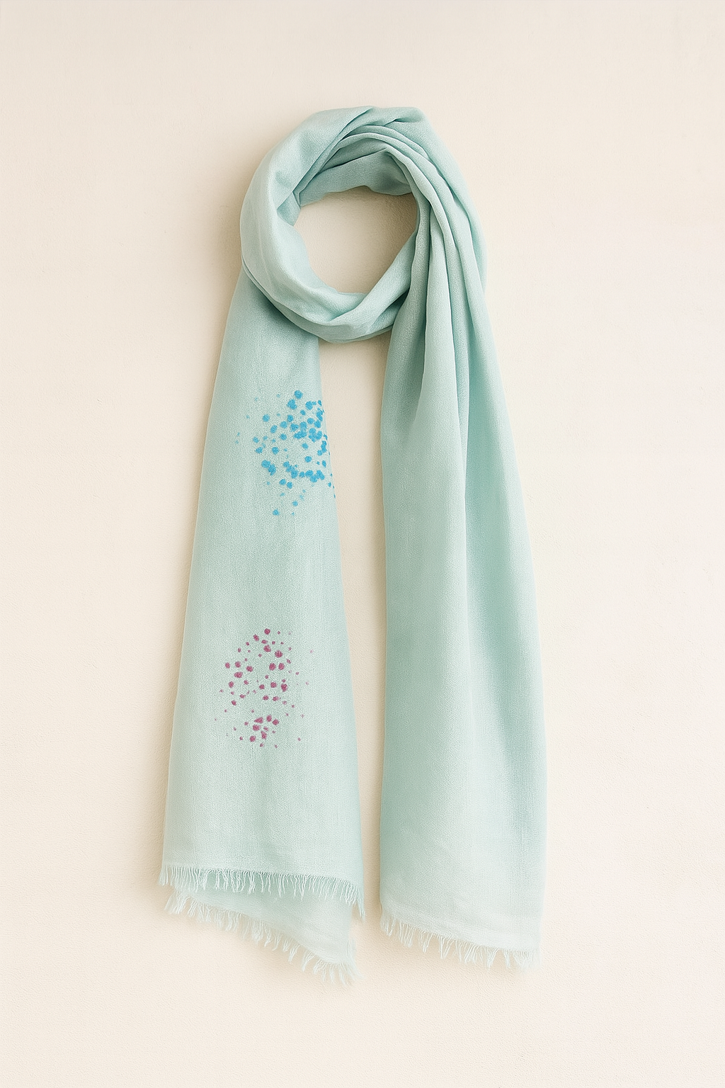 Light aqua satin weave pashmina-silk blend stole with spray-dyed blue and burgundy dot patterns, softly draped with fringe edges against a neutral background – handmade in Nepal.