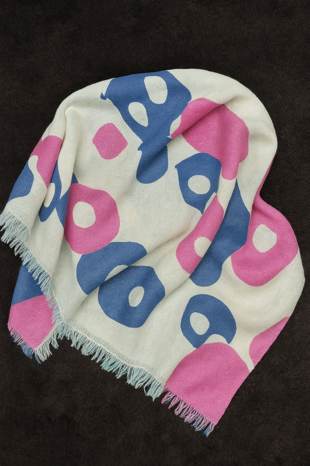 Lightweight bamboo stole with abstract pink and blue circular print, frayed edges, and soft drape, displayed on a dark textured background – sustainably handcrafted in Nepal.